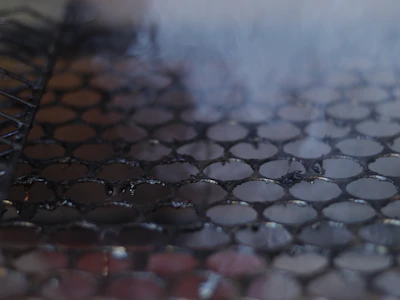 Close-up of a greasy kitchen grill before and after cleaning with Be Clean.