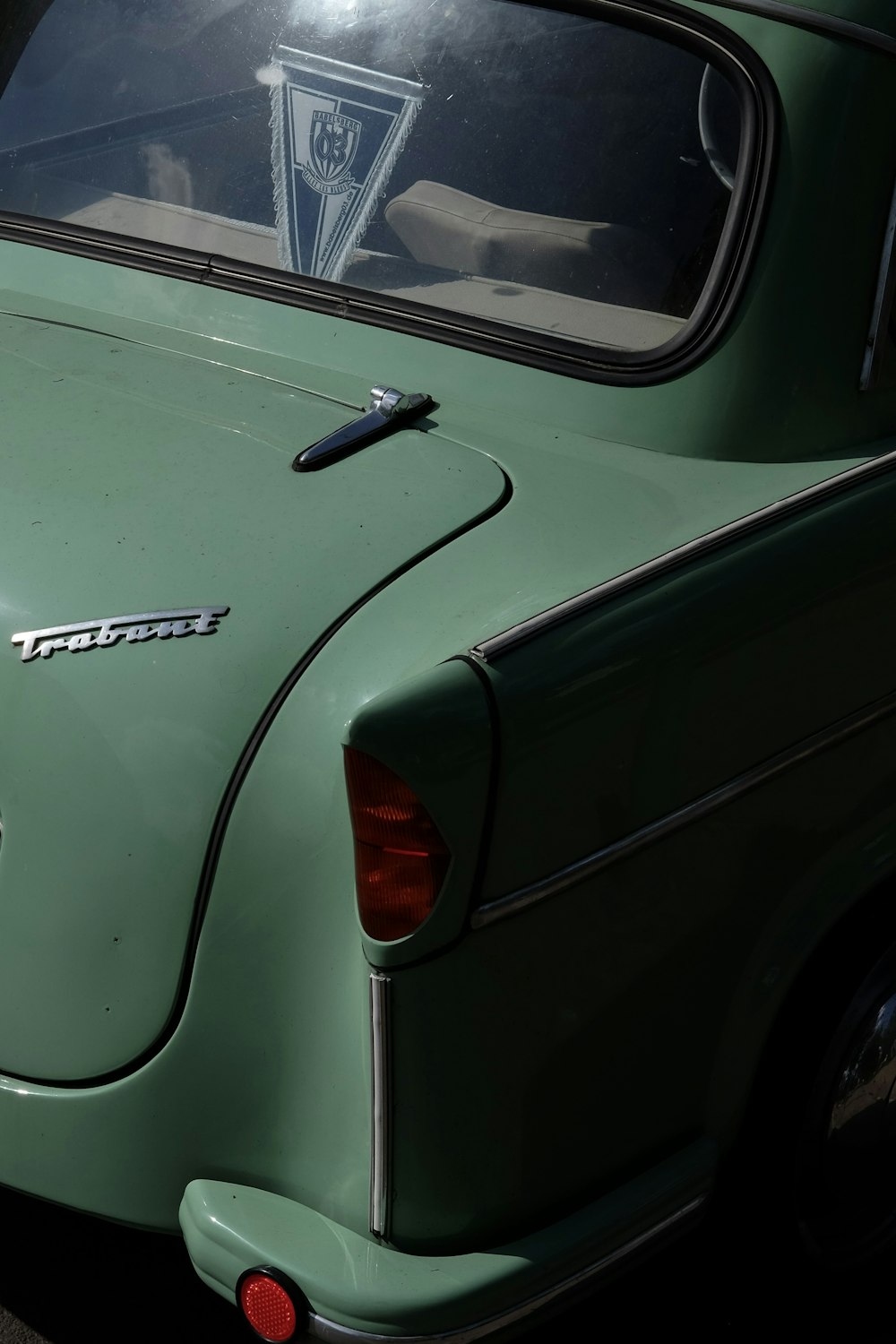 Un coche verde aparcado a un lado de la carretera