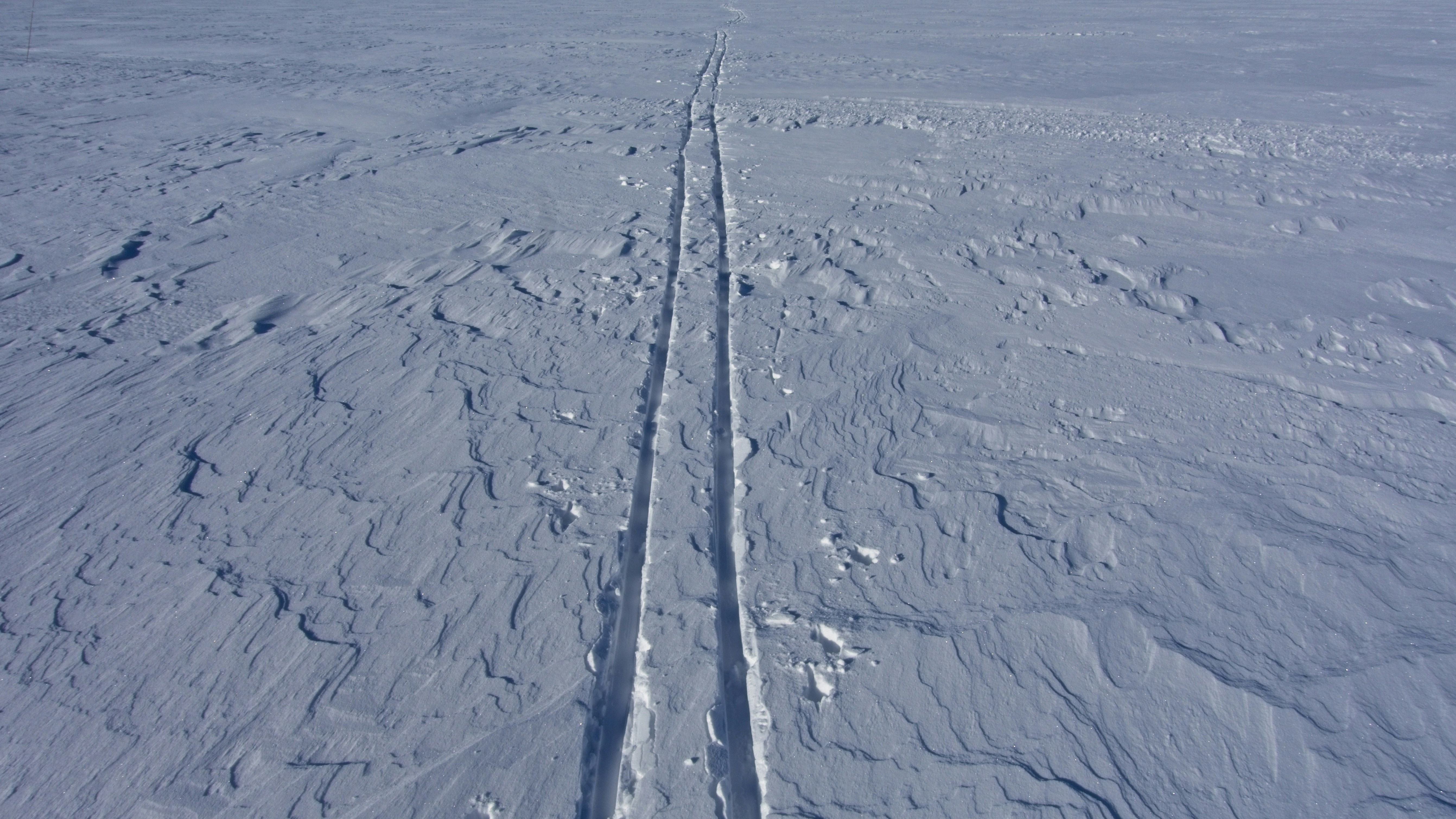 a person riding skis on a snowy surface, 