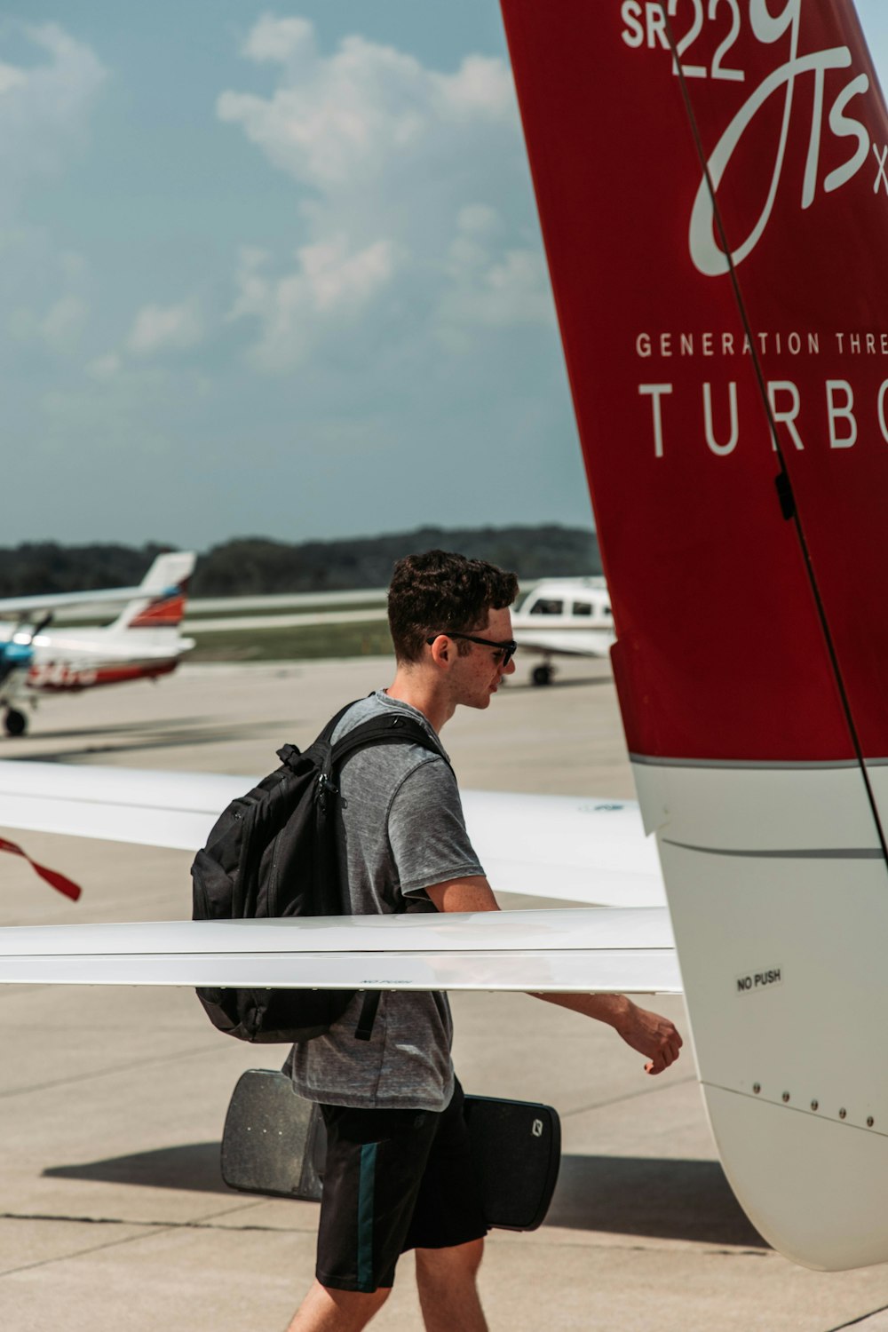 Ein Mann mit Rucksack geht auf ein Flugzeug zu