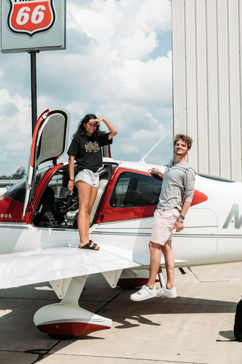 a man and a woman standing next to a small plane