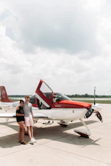 A happy couple boarding a plane, smiling with excitement for their romantic getaway.