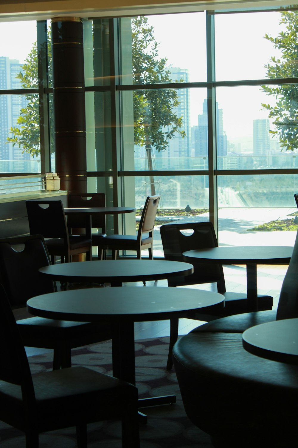 a room with tables and chairs and a large window