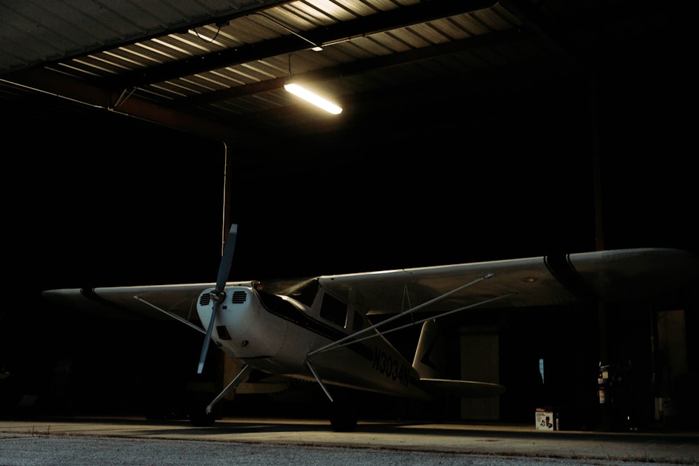 a small airplane parked in a hangar at night