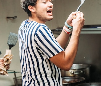 a man holding a spatula in a kitchen