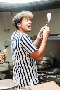 a man holding a spatula in a kitchen