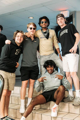 A warm gathering of international students sharing smiles on the Purdue campus.
