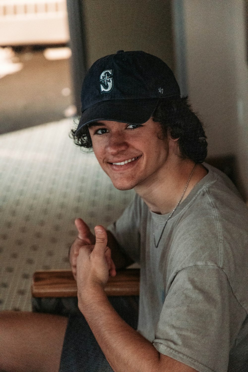 a man sitting on a bench wearing a hat