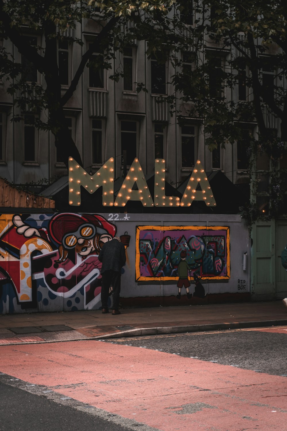 a couple of men standing next to a wall covered in graffiti