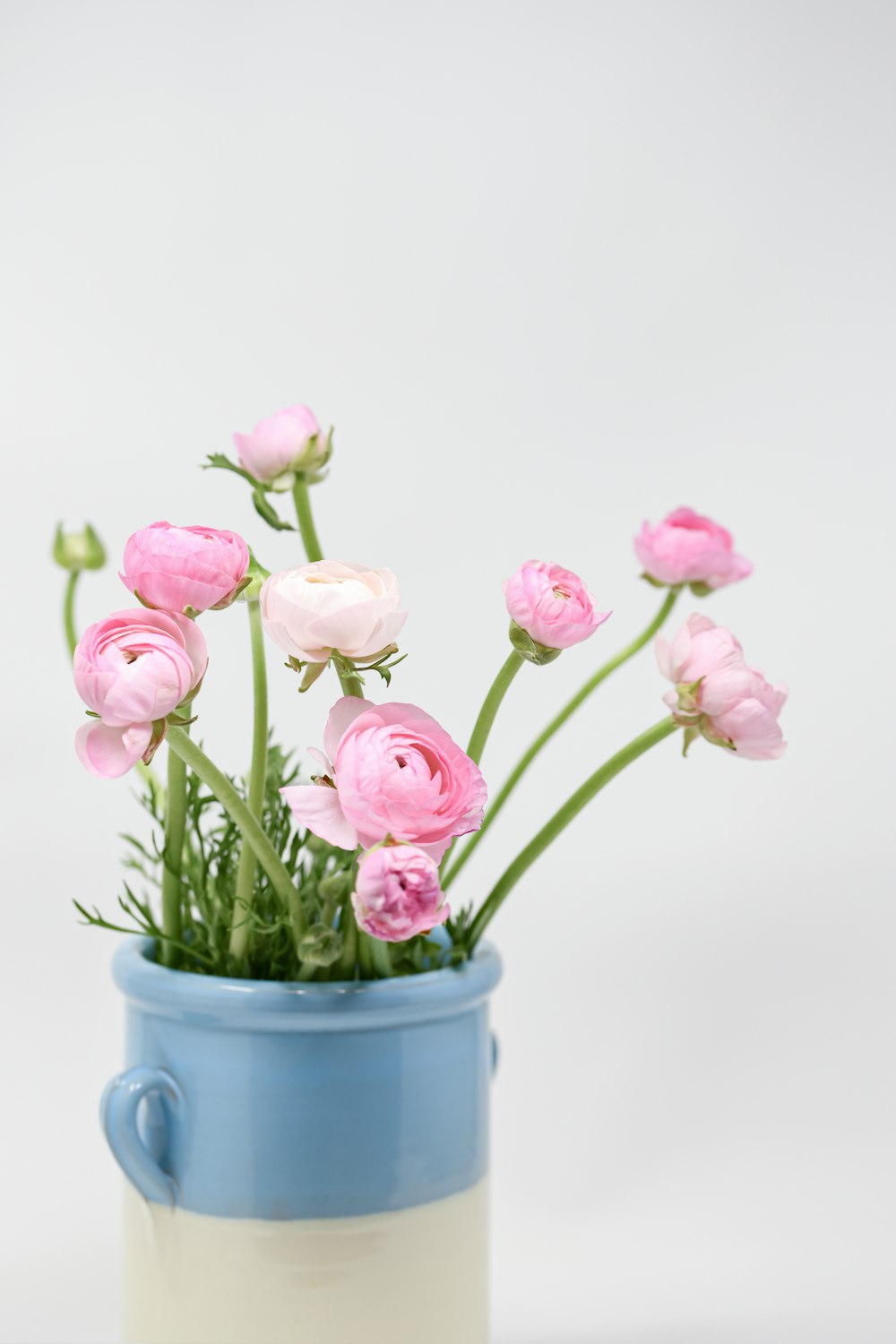 a blue and white cup with pink flowers in it