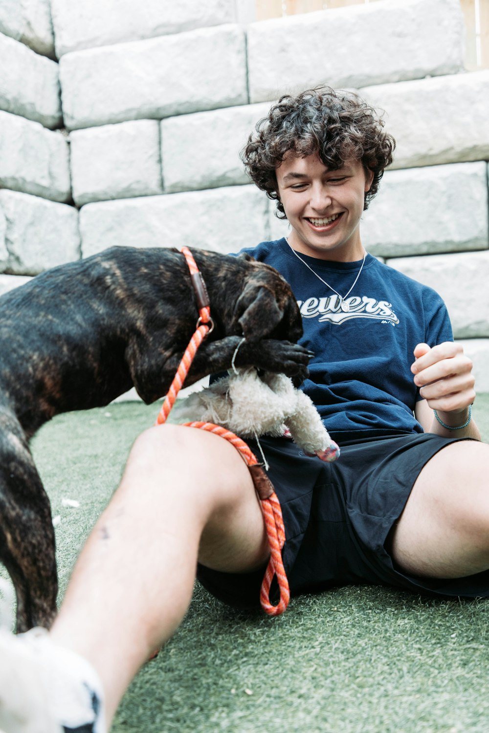 a man sitting on the ground with a dog