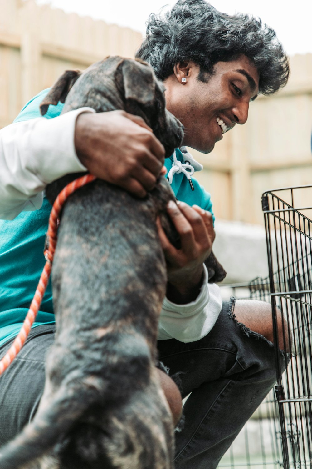 a man holding a dog in a cage