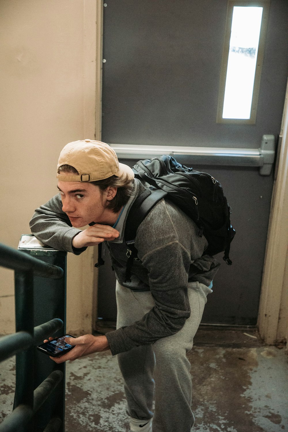 a man with a backpack leaning on a railing