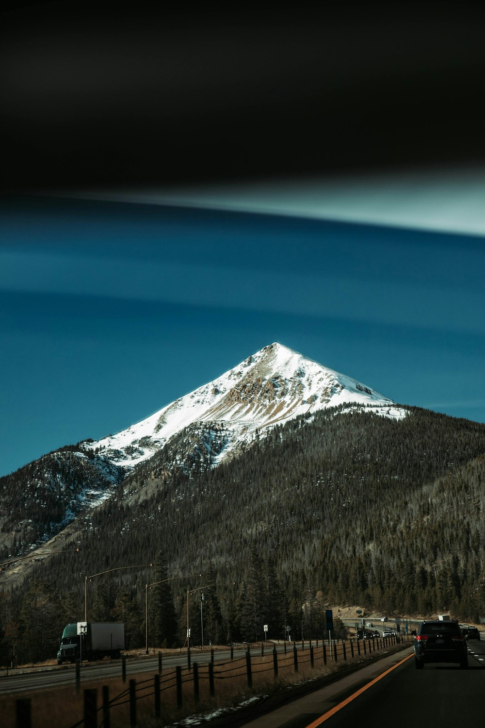a view of a snow covered mountain from a highway