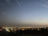 A cityscape of Edmonton at dusk with glowing lights and a clear sky.