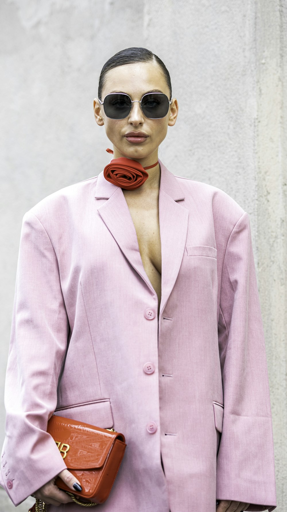 a woman wearing a pink suit and sunglasses