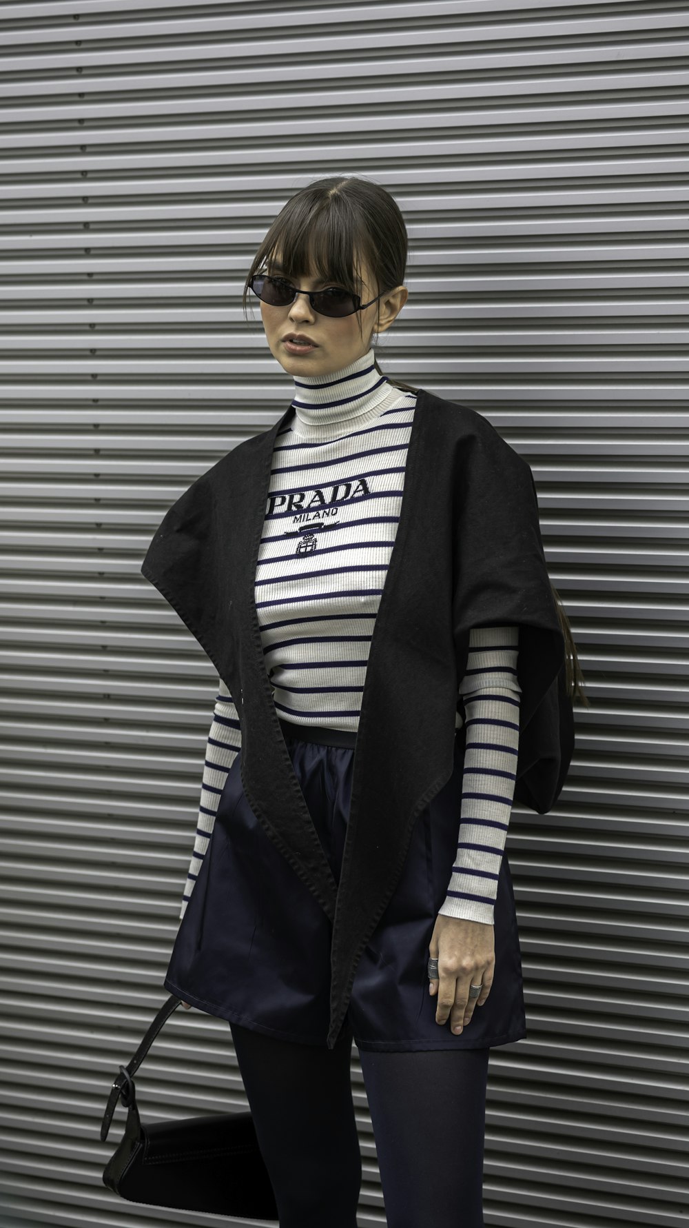 a woman standing in front of a metal wall