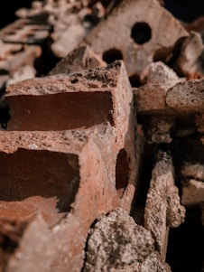 Close-up of neatly stacked reddish clay bricks showcasing their texture and quality.