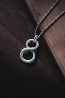 a silver necklace on a wooden surface
