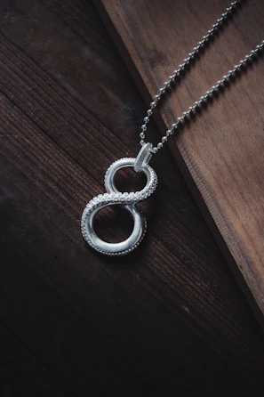 a silver necklace on a wooden surface