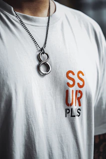 a man wearing a white tshirt and a necklace