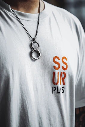 a man wearing a white tshirt and a necklace