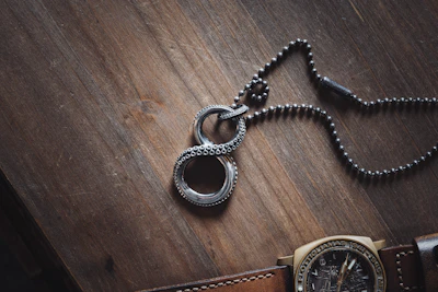 Flat lay of inspirational bracelet and necklace with faith symbols on a rustic wooden background.