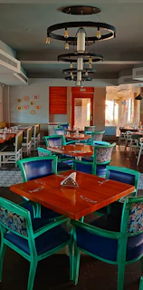 Chic dining area with a reclaimed wood table and colorful upholstered chairs