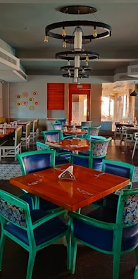 A vibrant dining area with colorful chairs and a statement chandelier adding character.