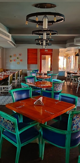 A sleek, modern steel and wood dining table with turquoise accents in a bright showroom.