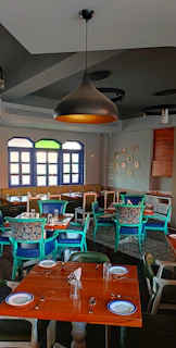 A warm, Scandinavian-style restaurant interior with wooden tables set for a cozy dinner.