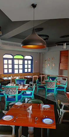 A warm, Scandinavian-style restaurant interior with wooden tables set for a cozy dinner.