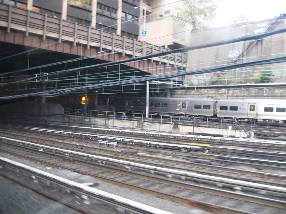 a train traveling through a train station next to a tall building