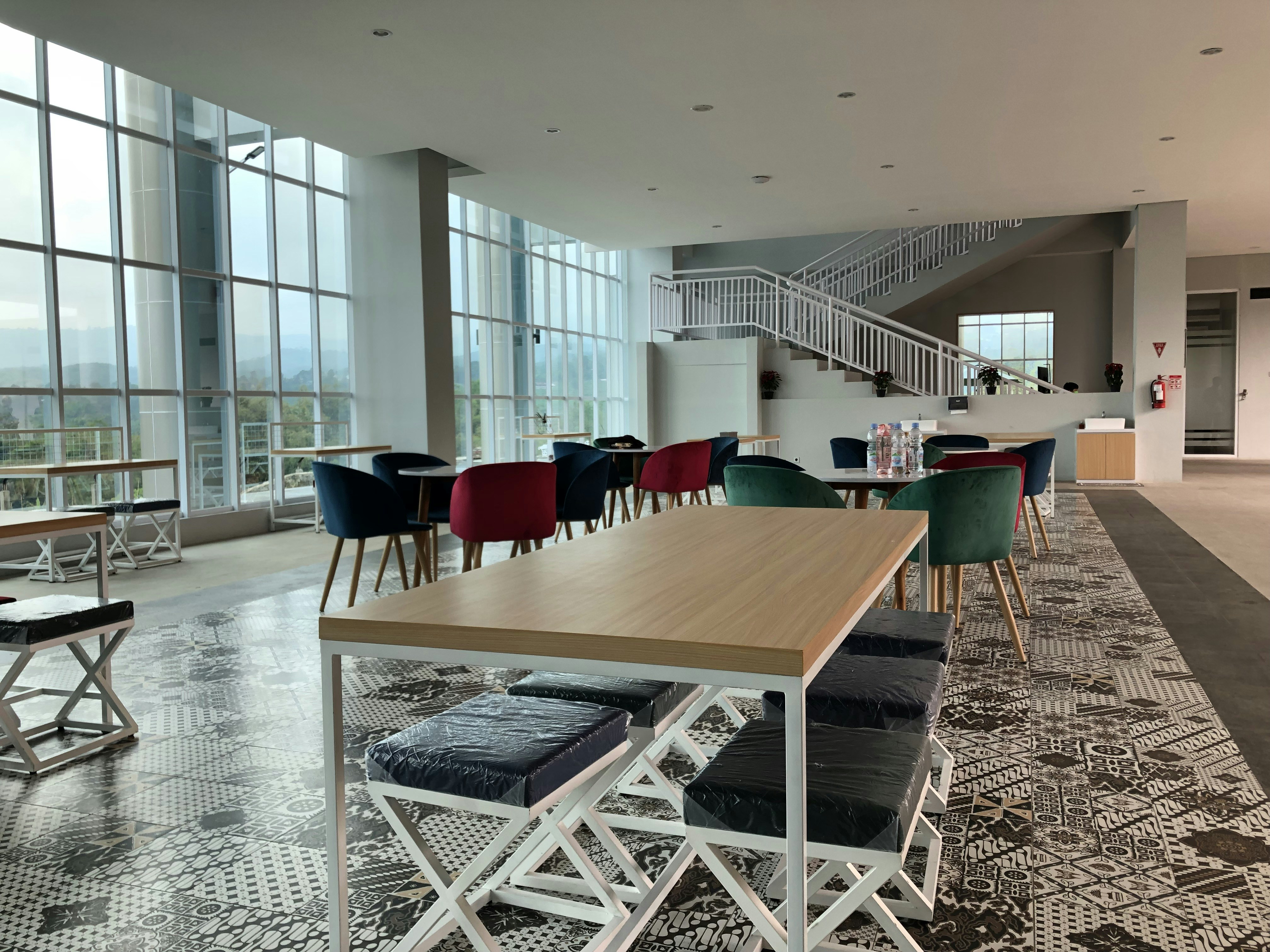 a room with a table, chairs, and a staircase