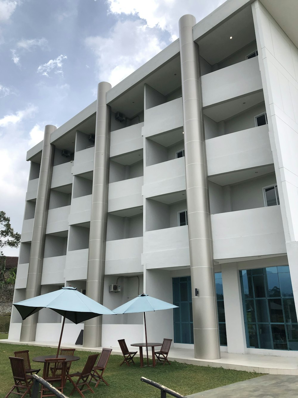 a large building with lawn chairs and umbrellas in front of it