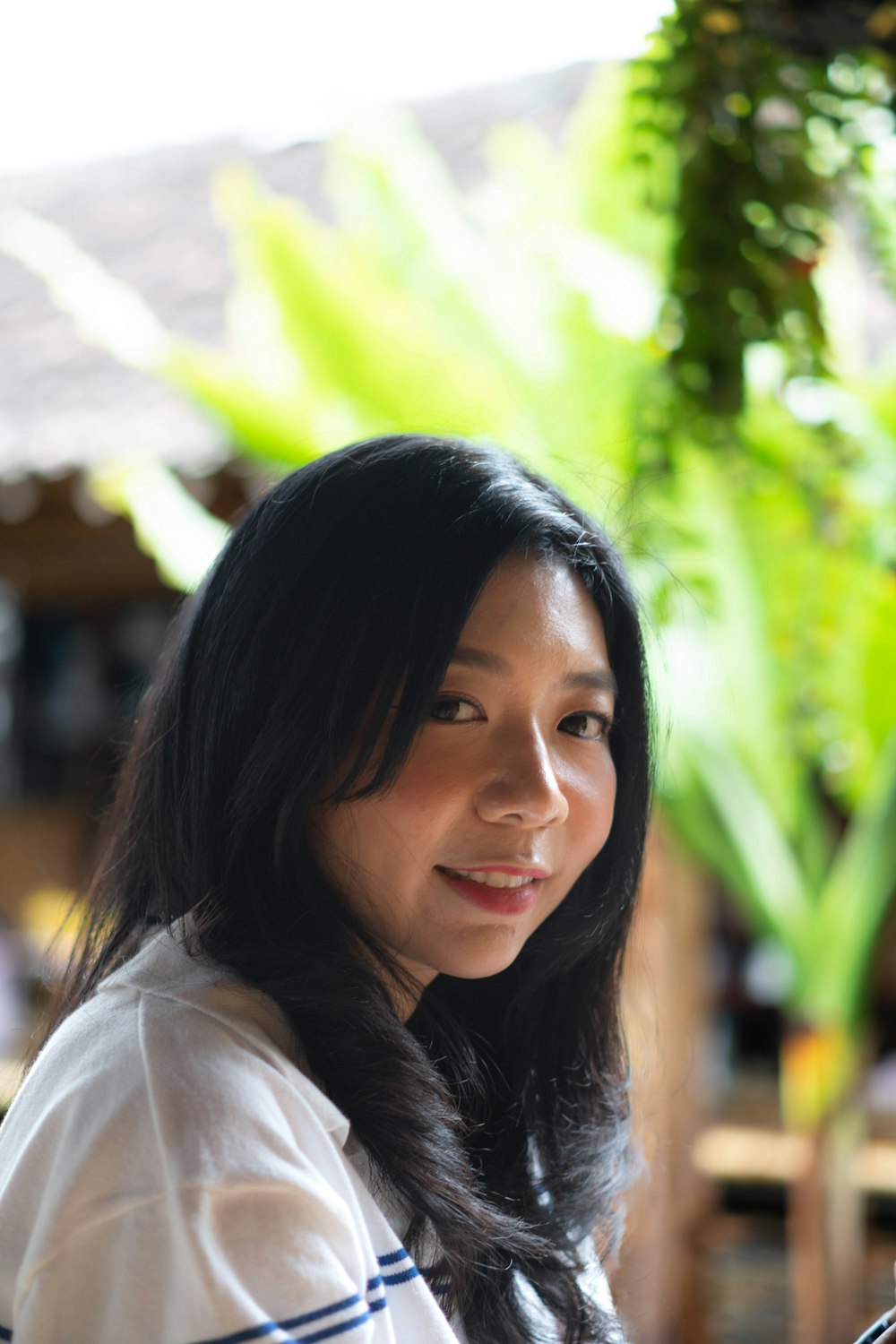 a woman in a white shirt holding a cell phone