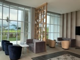 a living room filled with furniture and large windows
