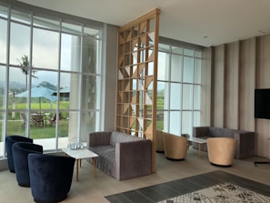 a living room filled with furniture and large windows