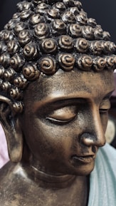 Close-up of a computer screen displaying AI code alongside a serene Buddha statue.