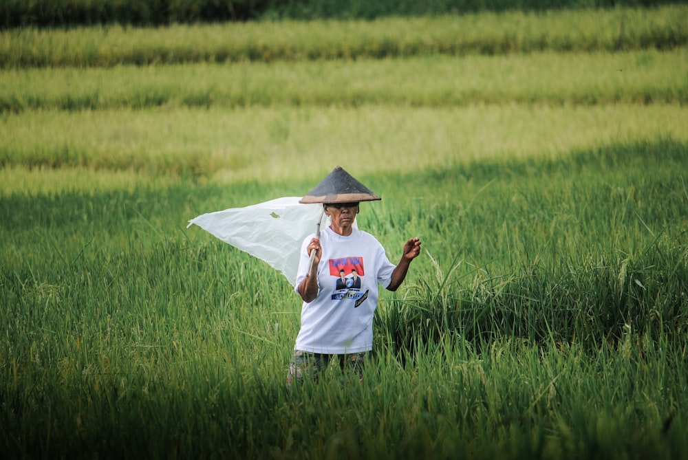 a man standing in a field with a hat on his head