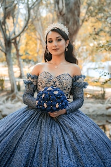 a woman in a blue dress holding a bouquet of flowers