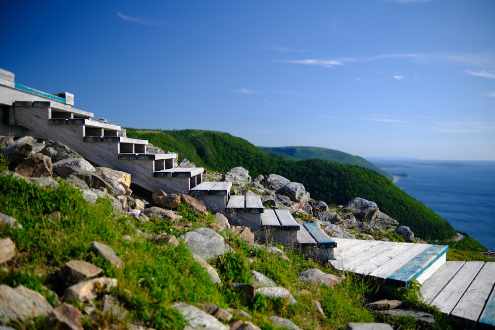 a view of some stairs on a hill by the ocean