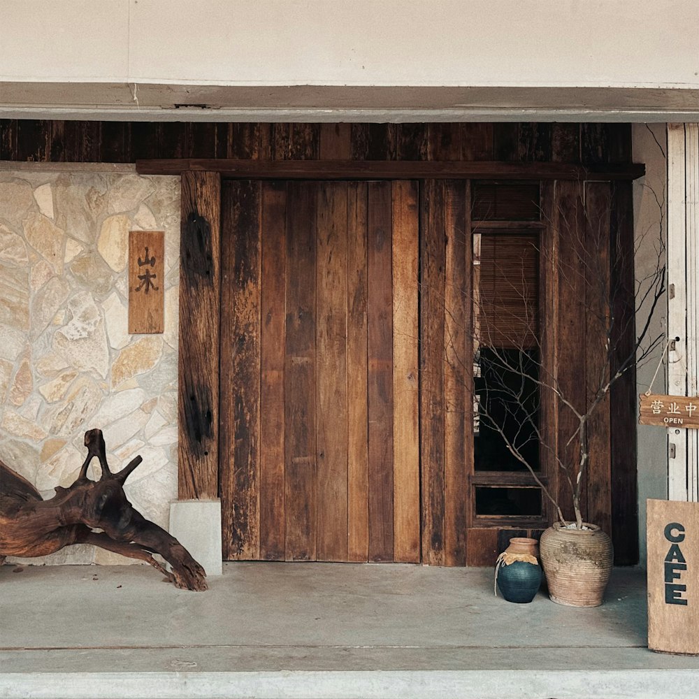 a wooden door and a stone wall in front of a building