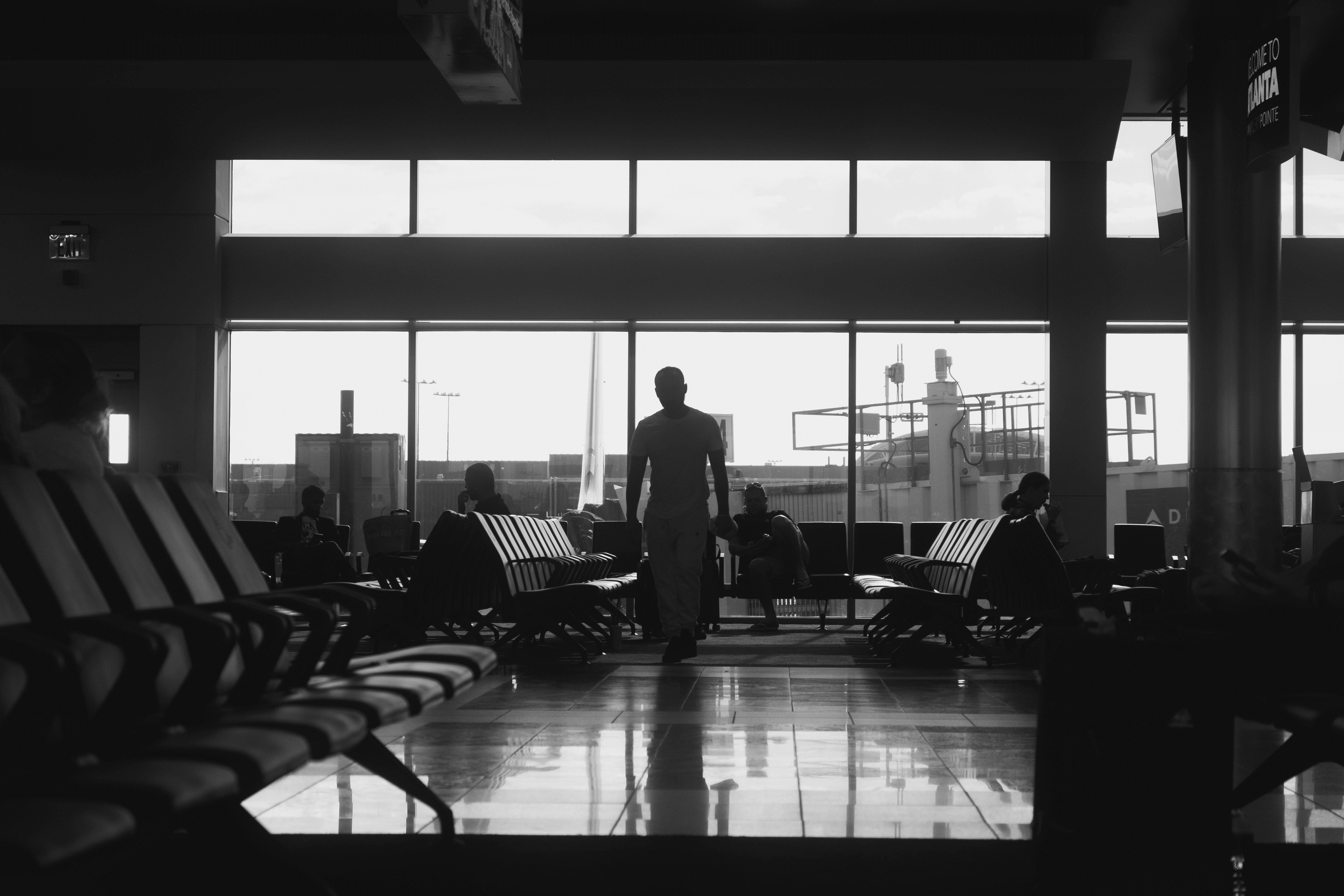 a black and white photo of a man standing in front of a window, 