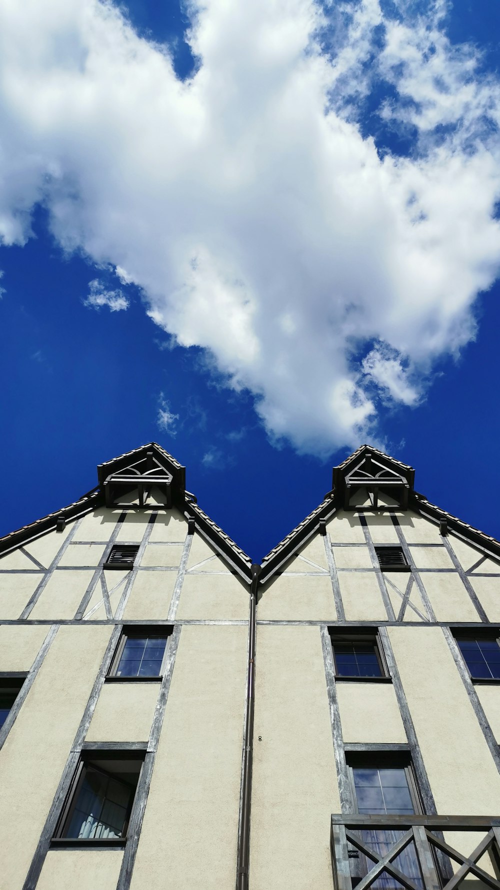 a tall building with two windows and a sky background