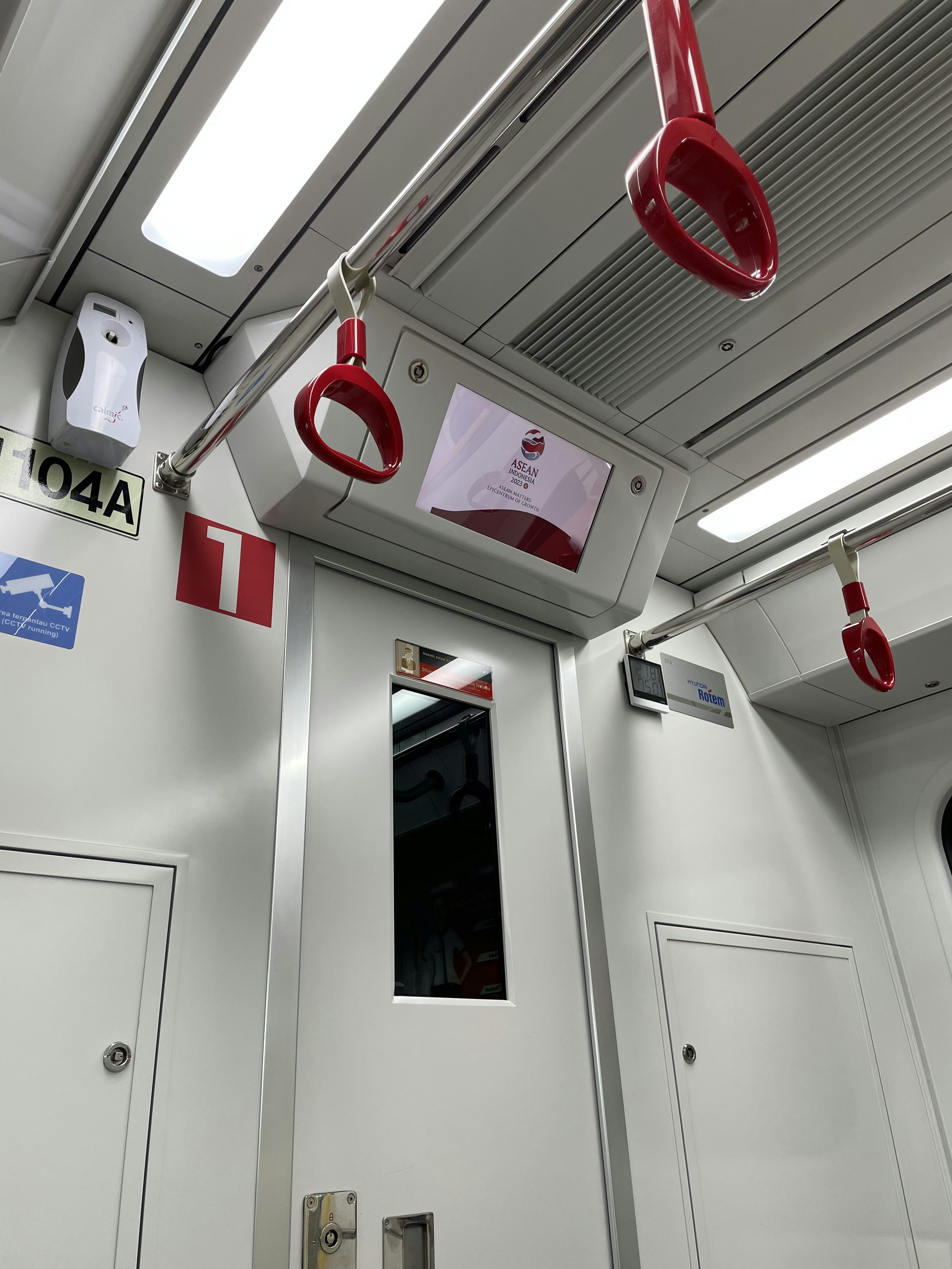 the inside of a train with a red light hanging from the ceiling