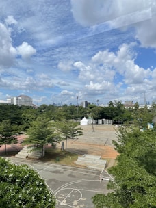 Wide open family-friendly spaces with children playing and sports courts in the background.