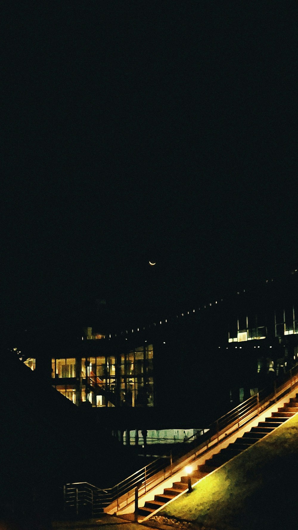 a building lit up at night with stairs leading up to it