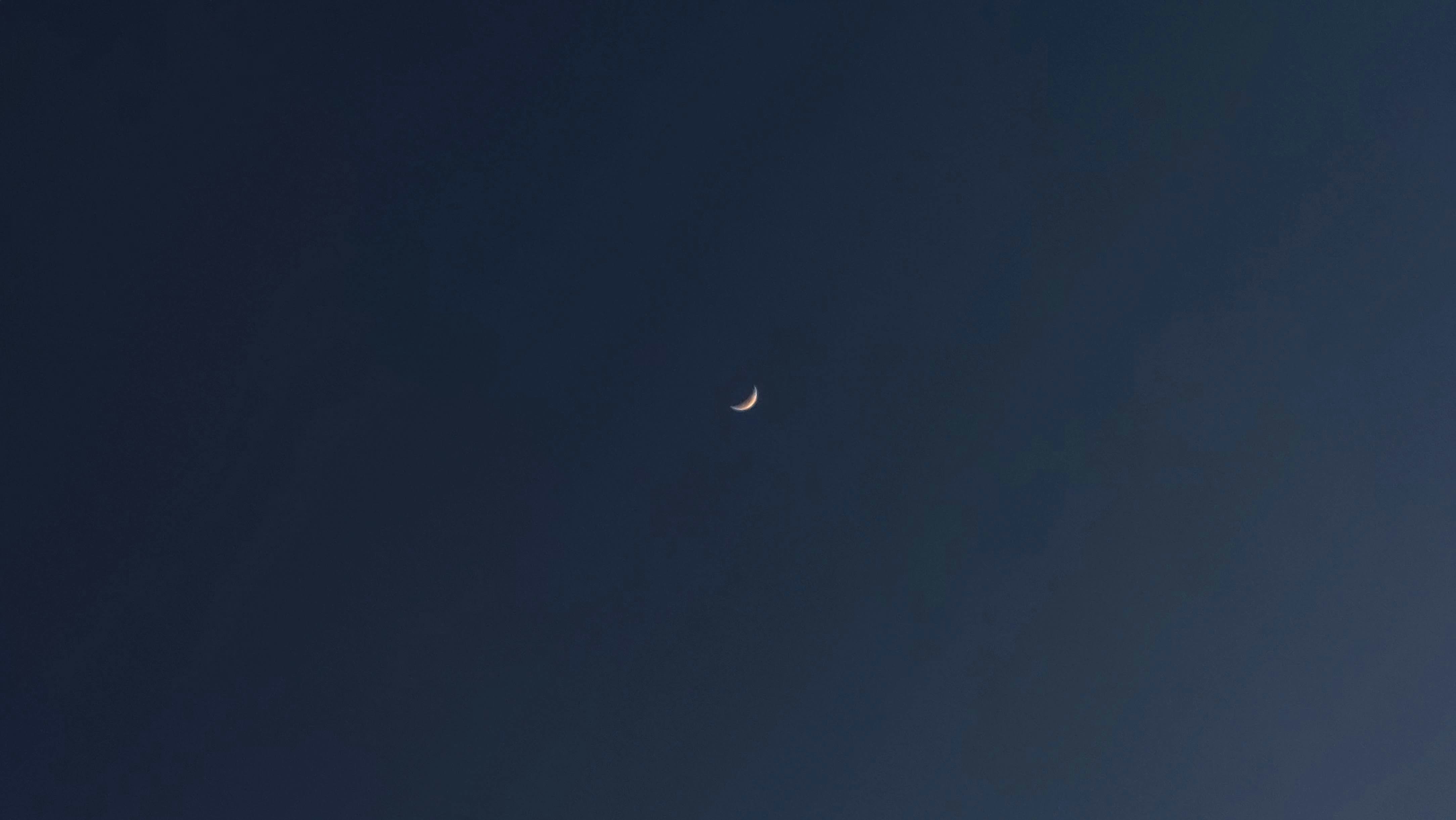 a half moon is seen in the sky