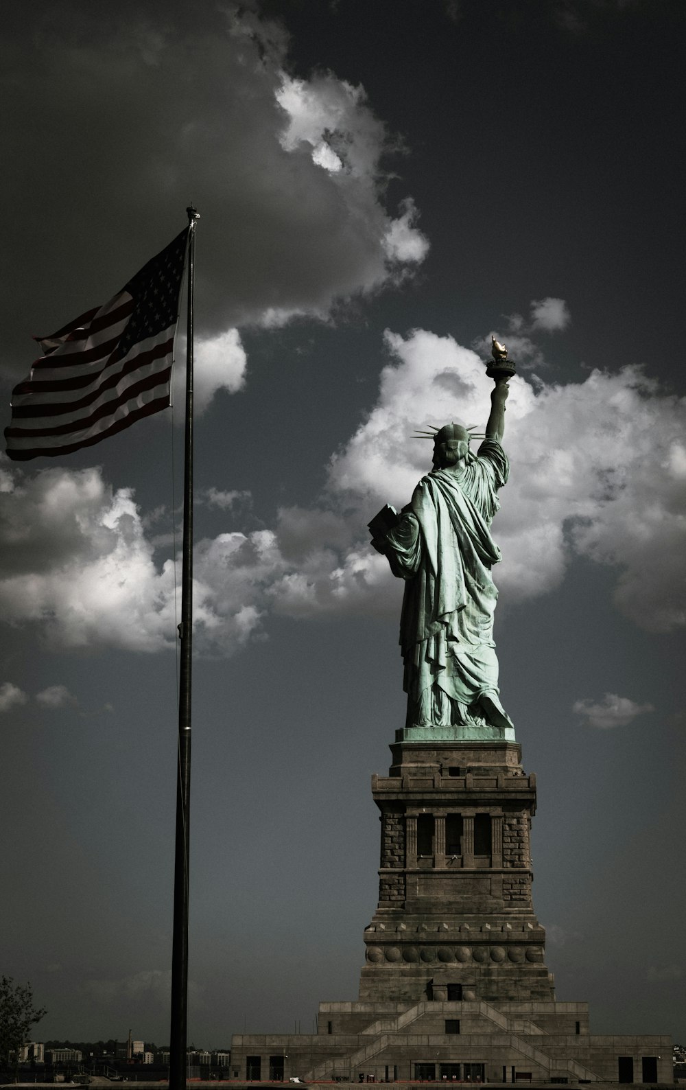 a statue of liberty with a flag flying in front of it